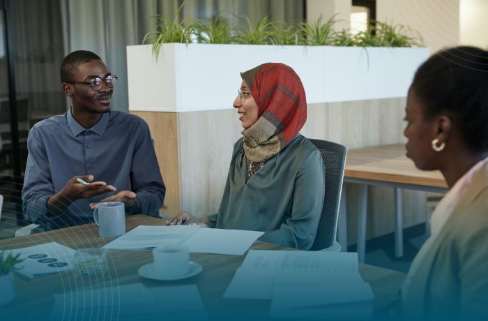 Three people sitting at a table, Marketing Translation Services.